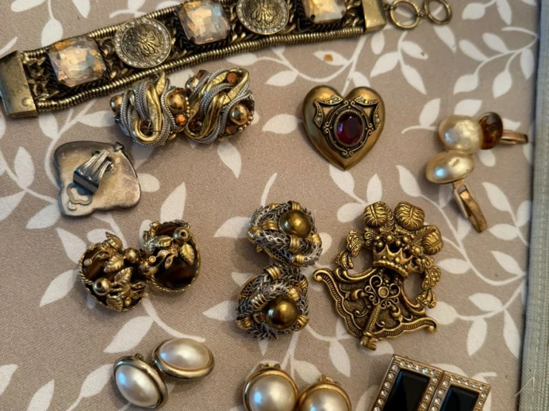 Goldschmuck und Zierknöpfe auf gemustertem Tuch