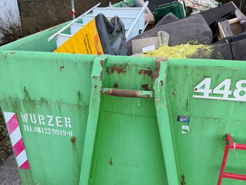 Gefüllter Entsorgungscontainer am Straßenrand