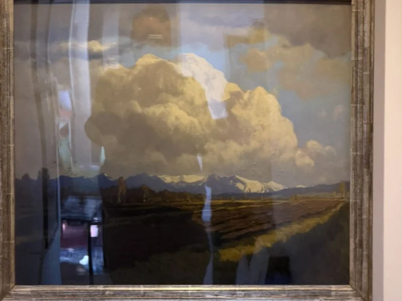 Gerahmtes Landschaftsgemälde mit Wolkenhimmel an der Wand