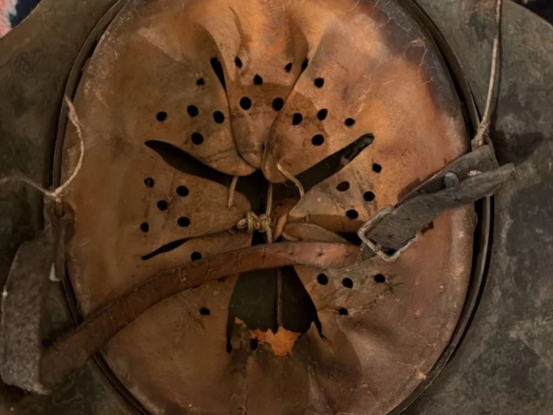 Historischer Stahlhelm auf einem gemusterten Teppich