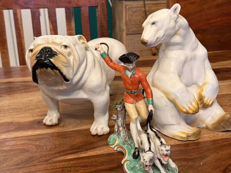 Porzellanfiguren: Bulldogge, Eisbär und Jägerfigur auf einem Tisch