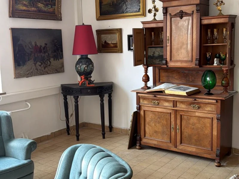 Wohnzimmer mit antiken Möbeln, Gemälden und Ohrensessel