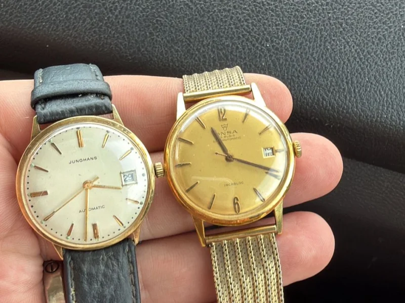 Zwei goldene Armbanduhren in der Hand gehalten