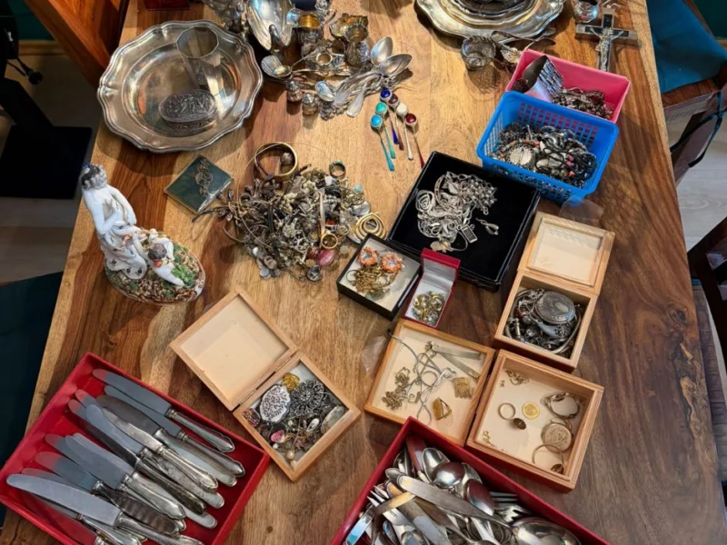 Tisch mit Besteckkassetten, Schmuck und Münzen aus einem Nachlass