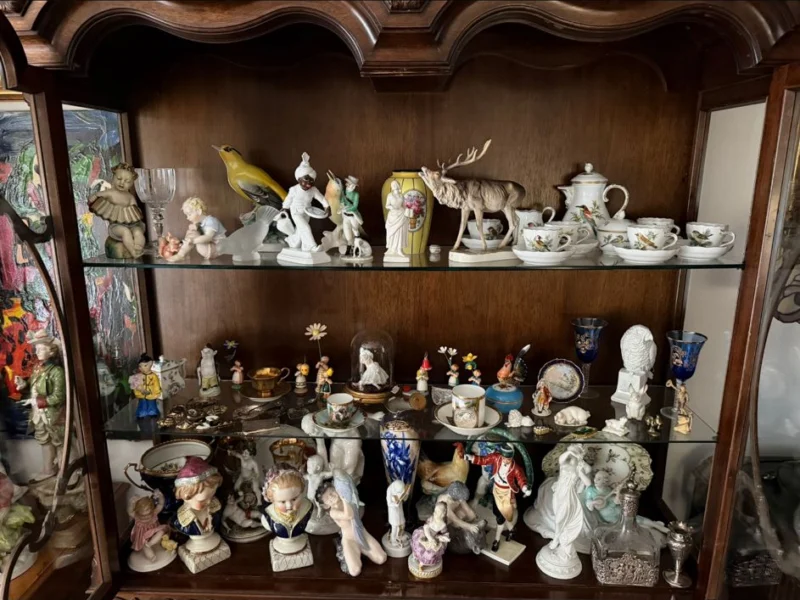 Regal mit mehreren Dutzend kleinen Porzellanfiguren