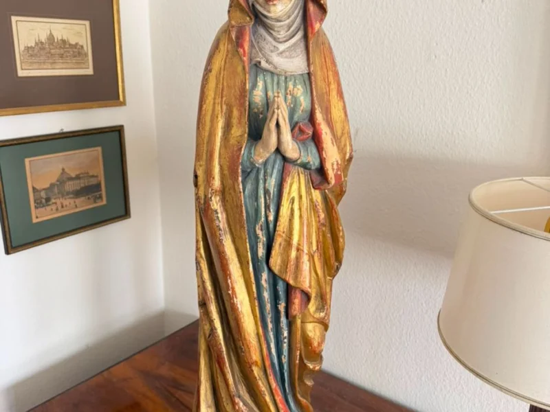 Gefasste Madonnenfigur aus Holz auf einer Kommode
