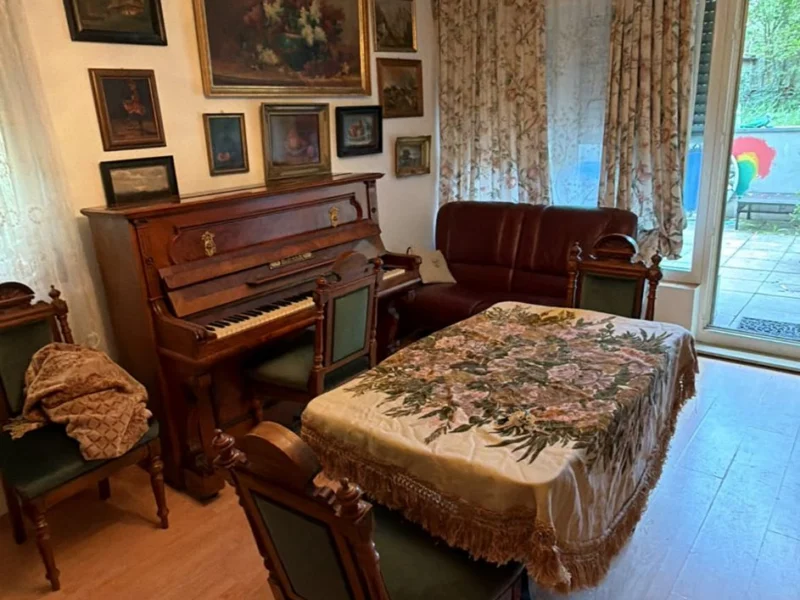 Esszimmer mit Kronleuchter, Klavier und antiken Möbeln