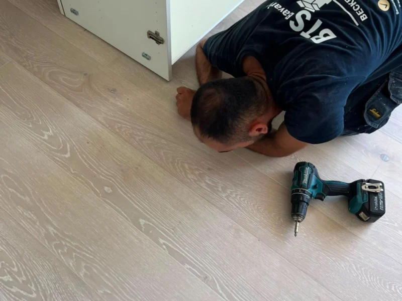 Mitarbeiter montiert ein Möbelstück am Boden