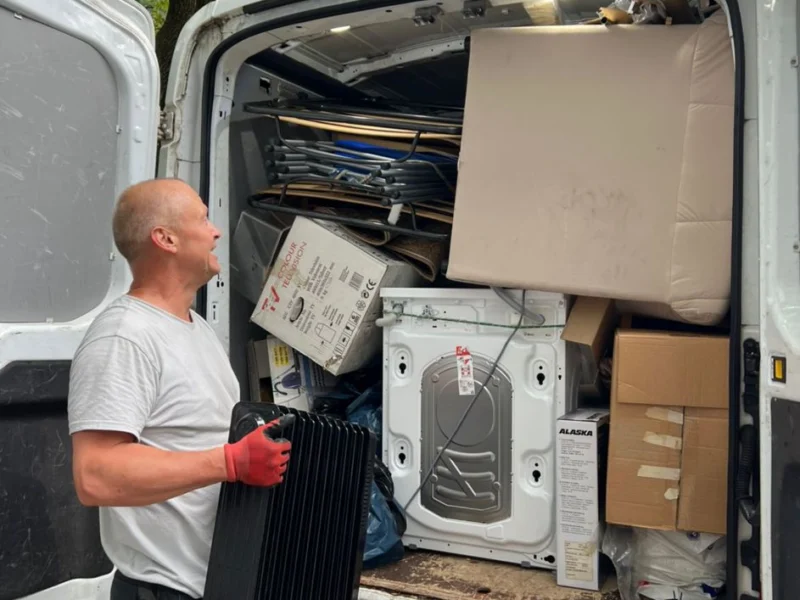 Mitarbeiter verlädt eine Waschmaschine in den Transporter