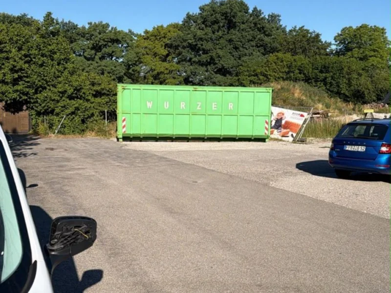 Container und Transporter auf einem Grundstück